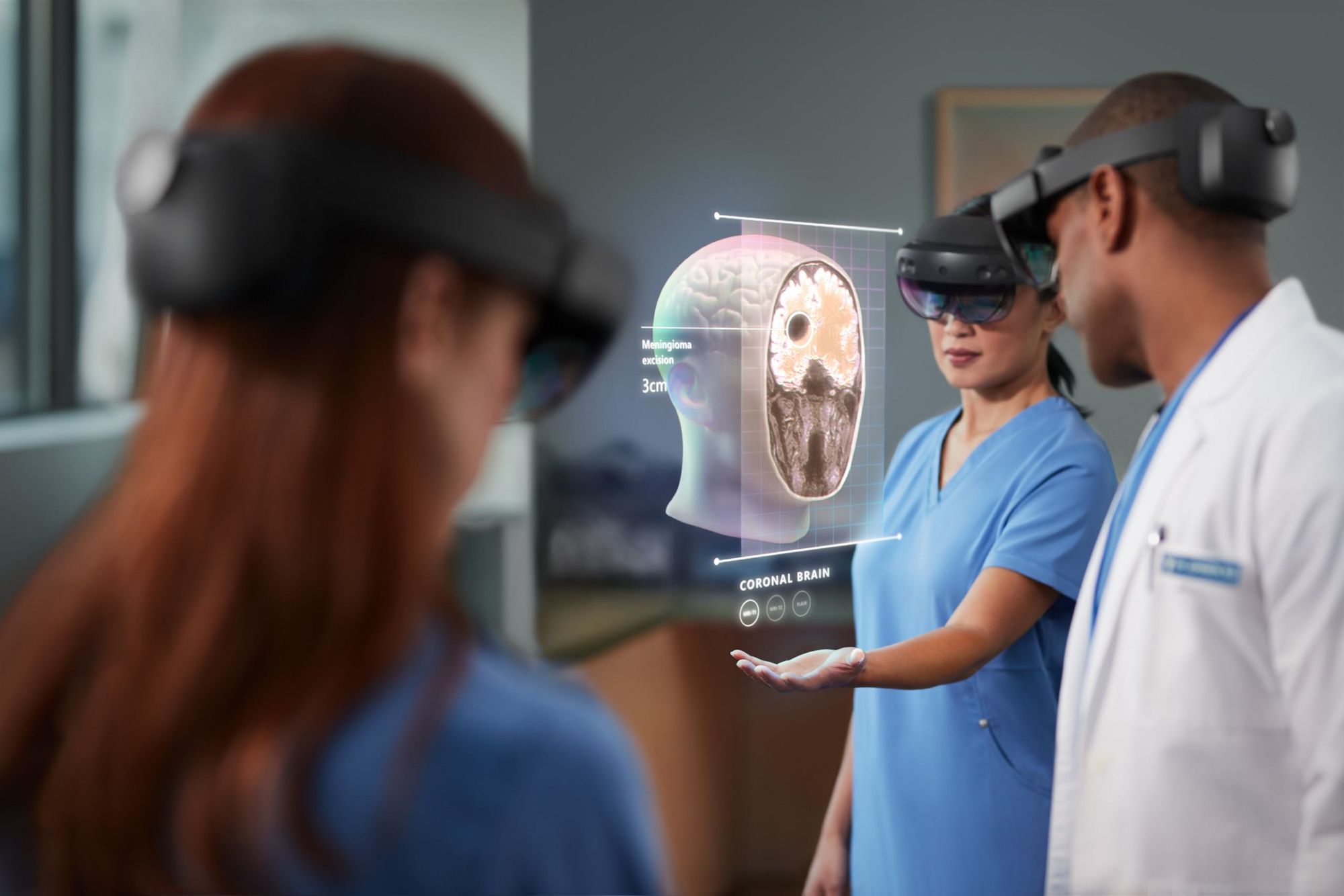 Two women and one man with XR headsets on, exploring a brain in Augmented Reality